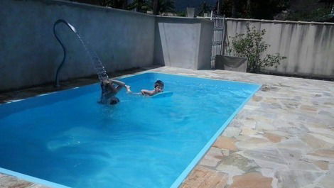 Piscina com área para mesas e cadeiras.