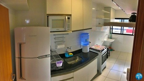 Cozinha completa com geladeira, fogão e micro ondas. 