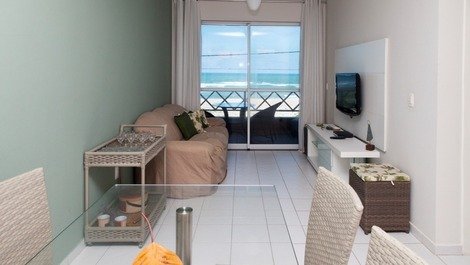 Sala de jantar e tv com vista para o mar
