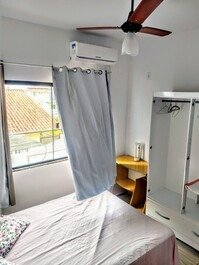 Quarto média com ar condicionado e ventilador de teto e uma cama de casal