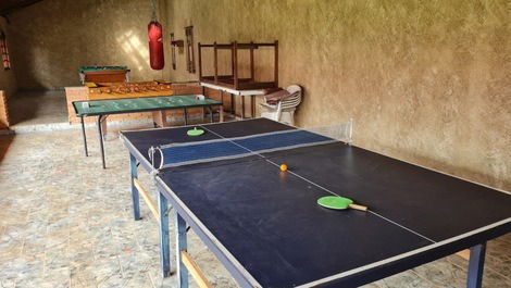 Salao de jogos com mesa de ping pong, pebolim, botao e bilhar