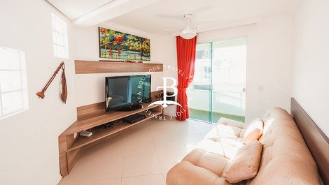  área de estar conta com um sofá-cama, varanda, tv e ventilador de teto