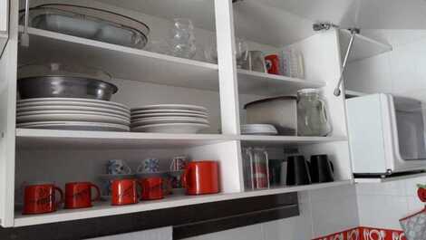 Cozinha com panelas e louças completa. 