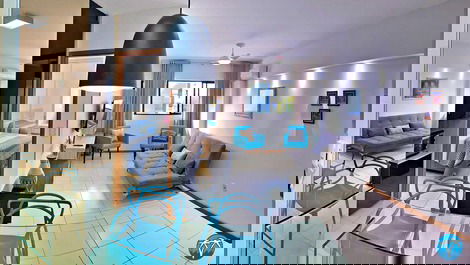 Sala de estar espaçosa com sofá retrátil e smart tv.