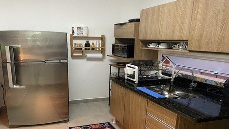 Cozinha com geladeira, microondas, liquidificador, cafeteria e sanduicheira 