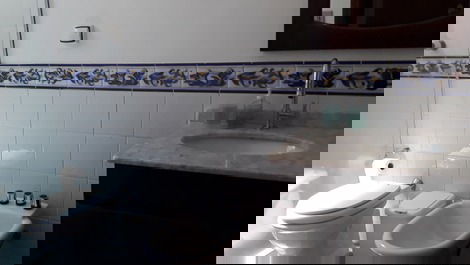 Banheiro com box de vidro e bidê.