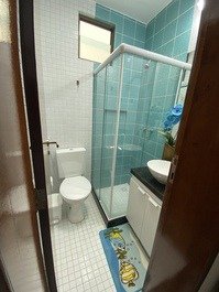Banheiro social com chuveiro aquecido, box e espelho. 