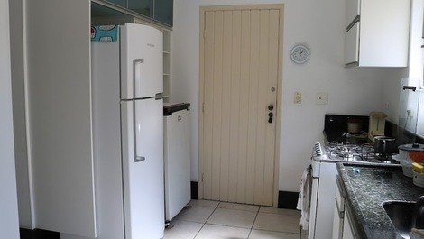 Cozinha com fogão, freezer, microondas e utensílios