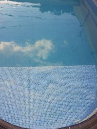 A nuvem refletindo na água da piscina no final da tarde