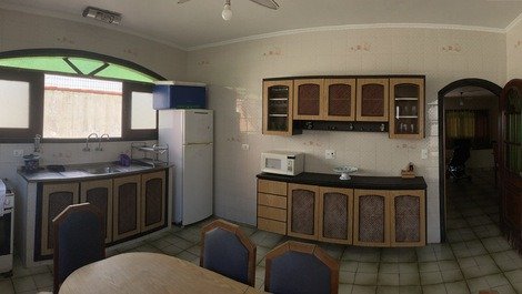 Cozinha kitchen com ventilador de teto, fogao, geladeira com freezer, microondas e utensílios de cozinha