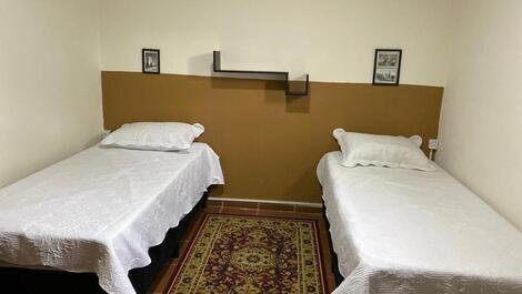 Duas camas no quarto de solteiro com cobre leito e dois travesseiros 