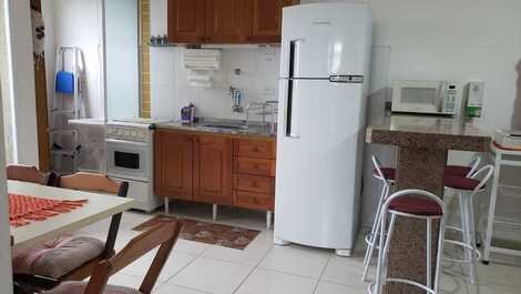 Cozinha conjugada com sala (geladeira duplex, fogão 4 bocas, armários, utensílios)