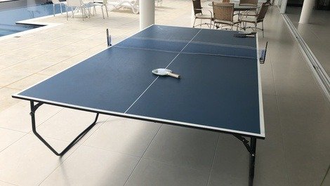 Mesa de ping-pong com raquetes e bolas. 