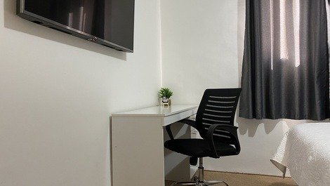 Espaço home office com escrivaninha e cadeira giratória modelo diretor