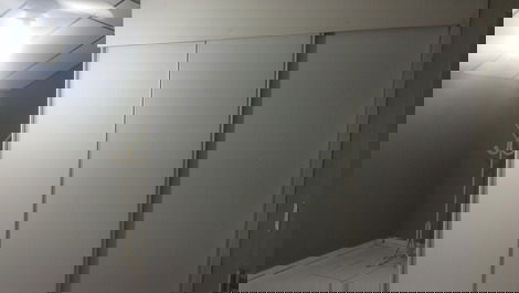 Quarto com amplo armário e cabideiro de chão 