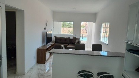 Sala com tv de led e sofá na sala com vista para piscina e varanda 
