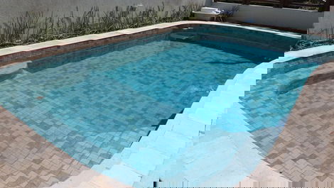 Moderniza o a piscina de dia verde e a noite iluminada de azul