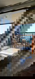 Varanda com mesa de jantar de frente para o mar