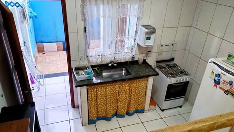 Cozinha e atrás tem uma pequena varanda c churrasqueira e um lavabo