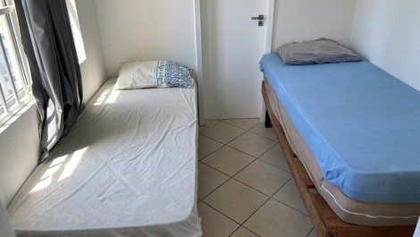 Dormitório com duas camas de solteiro e bwc