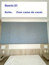 Quarto 01. suíte. com banheiro, cama de casal, armário, tv e ar condicionado.