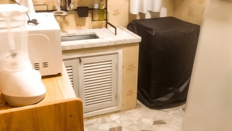 Gabinete e prateleira e fogão a gaz com utensílios na cozinha