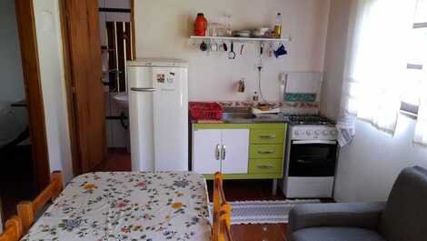 Chale color cocina de zanahoria y pequeña sala con chimenea