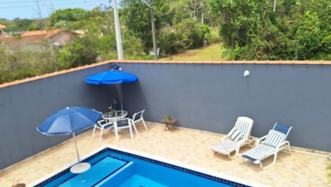 Área da piscina com cadeiras de praia,próxima ao espaço gourmet.