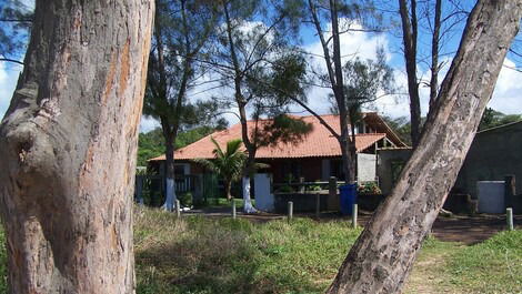 Pé na areia de frente para a casa