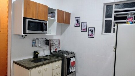 Cozinha integrada equipada com fogão, geladeira, microondas, acessórios 