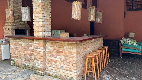 Area gourmet - balcao bar amplo dando para o deck de pedras