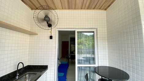 Varanda gourmet integrada ao apartamento, com ventilador de parede.