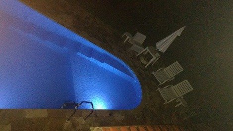 Vista da piscina noturna pela sacada da suite master