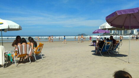 Praia com cadeiras e guarda sol fornecidos pelo apto