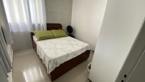 Quarto com um ventilador, um armário e uma arara 