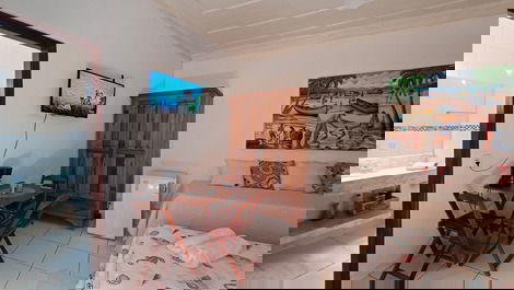 Panorâmica do quarto, incluindo camas, frigobar, armário, tv, mesas, cadeiras e entrada do banheiro