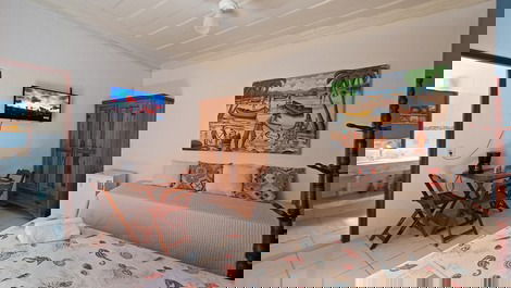 Panorâmica do quarto, incluindo camas, frigobar, armário, tv, mesas, cadeiras e entrada do banheiro