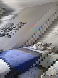 Quarto social com ar condicionado e 1 cama de solteiro.