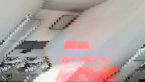 Quarto com cama de casal, ar condicionado, cadeira, armário aéreo e blackout