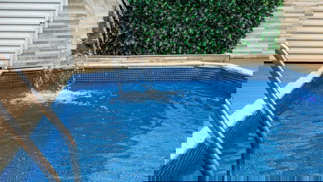 Piscina com cascata, luz de led, e espreguiçadeira, perfeita para relaxar e curtir o sol. 