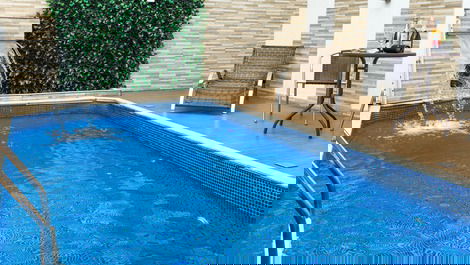 Piscina com cascata, luz de led, e espreguiçadeira, perfeita para relaxar e curtir o sol. 