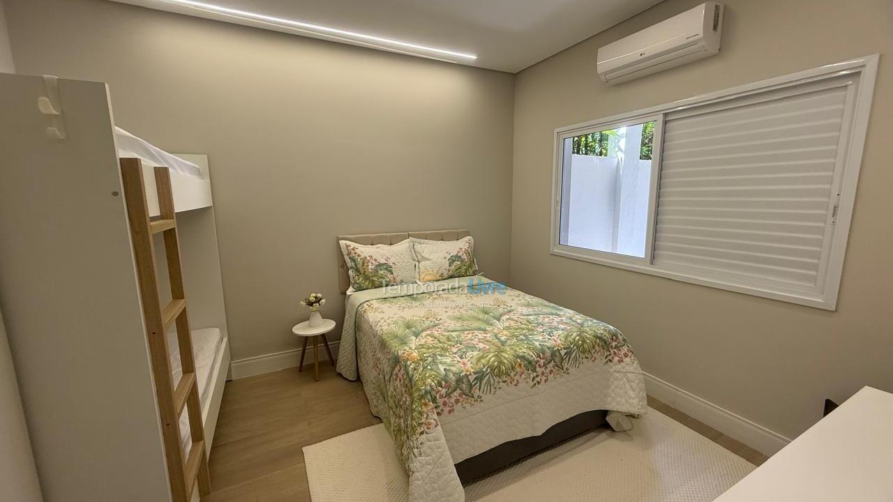 Suíte branca, cama de casal e beliche Casa para aluguel de temporada em Bertioga (Condominio Morada da Praia)