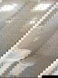 Casa com varanda-banheiro com box de vidro e chuveiro elétrico
