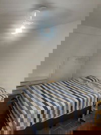 Quarto com cabideiro e gaveteiro.