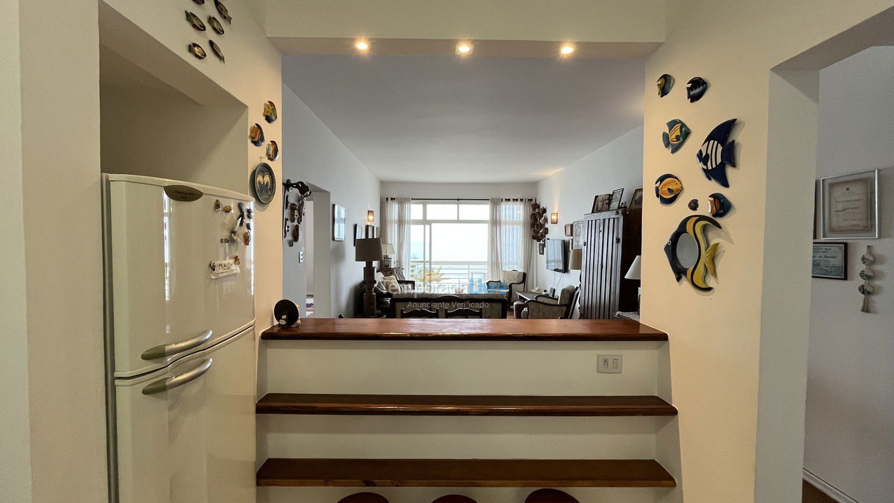 Cozinha vista para a sala de jantar e tv Apartamento para aluguel de temporada em Guarujá (Pitangueiras)