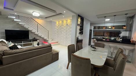 Sala de jantar ambiente espaçoso e integrado, ideal para refeições em grupo.