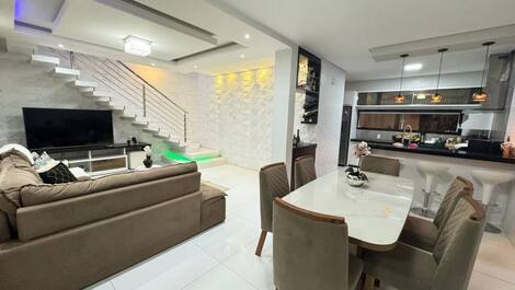 Sala de jantar ambiente espaçoso e integrado, ideal para refeições em grupo.