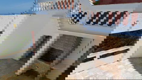 Churrasqueira  da cobertura,  tem cadeiras e mesas